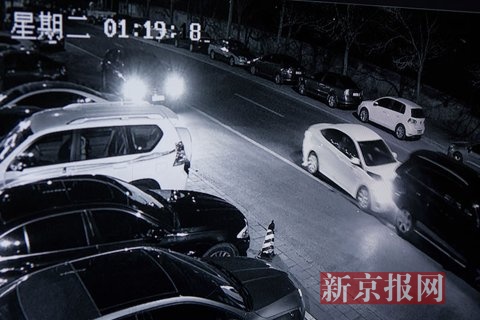 奥迪车突然猛向后退,撞击白色车辆前部,随后从左侧及前方两车夹缝中开出,并撞到站立在左前方的男子,向南逃跑。视频翻拍。新京报记者 李强 摄