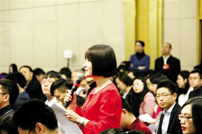 图为本报记者杨烨在向肖亚庆提问。