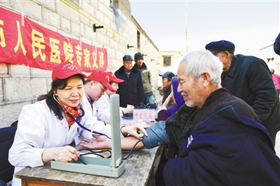河北邢台市人民医院的医务志愿者组成爱心医疗小分队，为太行山区的留守、孤寡老人义诊。图为3月19日，医生正在为村里老人测量血压。本报记者 史自强摄