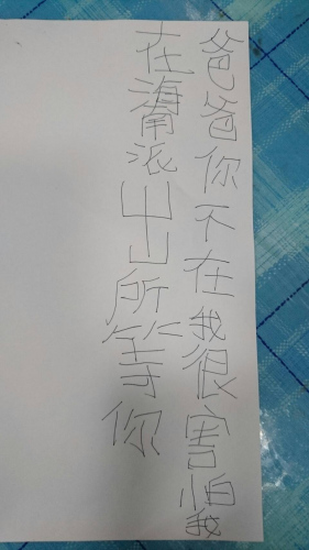 警察带男童回家发现家长不在，只好叫男童写下字条， 准备再带回派出所时男童父亲刚好回家。台湾《联合报》记者周宗祯/翻摄