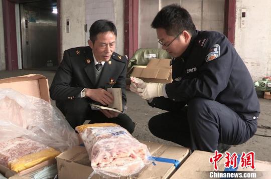 图为海关关员与缉私警察正在仓库清点被扣冻品。 杨卫 摄