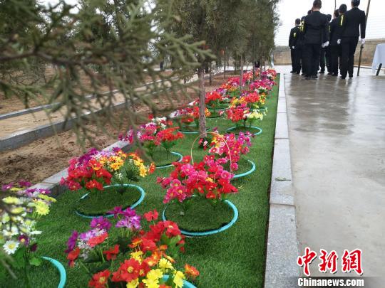 图为:安葬仪式结束,礼仪师离开。花下的无名尸长眠于此。 刘小红 摄