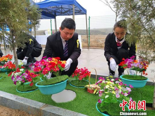 图为:礼仪师正在封穴。 刘小红 摄