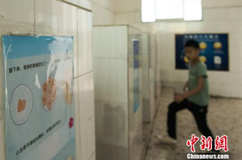 图为广西柳州文惠小学在男厕所悬挂的性知识绘本,让学生在排队上厕所,或蹲厕所时,抬头即能看见。 黄威铭 摄