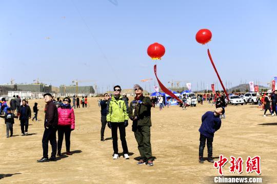 图为风筝爱好者放飞风筝引起民众围观。 高庆国 摄