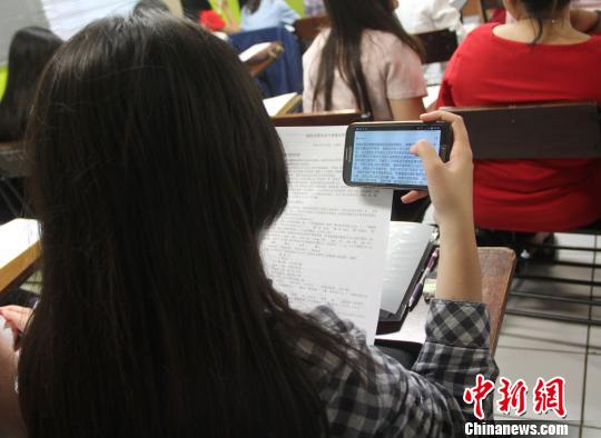 图为一学生用手机扫描软件现场学习。 林永传 摄