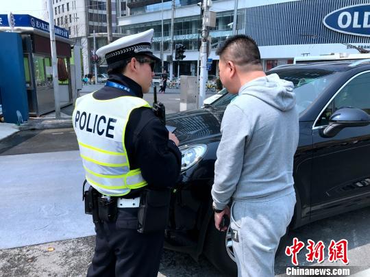 上海南京西路华山路路口,交警对一名违反交通法规的驾驶员进行处罚。 王子涛 摄