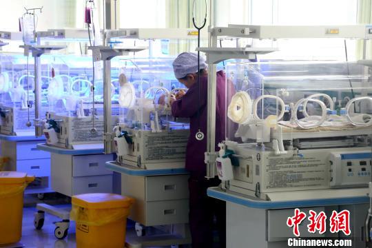 图为青海省海南藏族自治州人民医院的新生儿科重症监护室内,护士正在照顾保温箱里的早产儿。 张海雯 摄