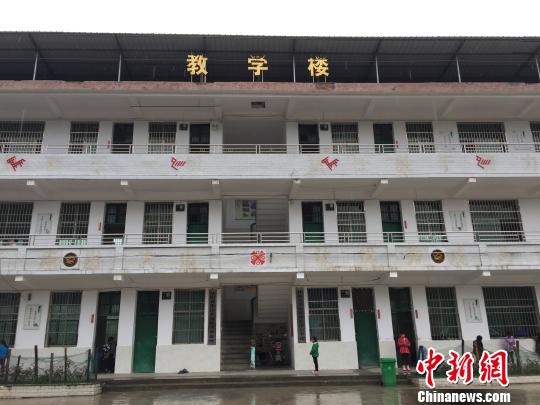 华山瑶族中心学校里,瑶歌传承基地的牌匾挂在教学楼的门口。 鲁毅 摄