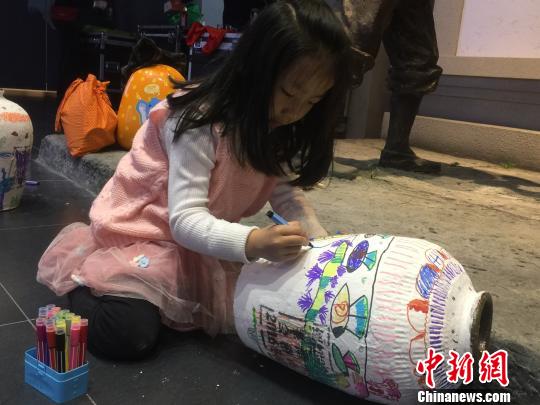 图为活动现场小朋友在酒坛上作画 孔雁婷 摄