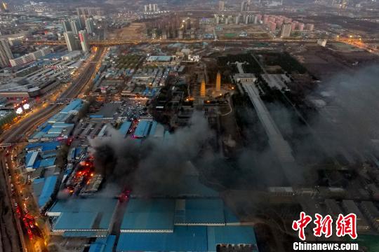 30日下午17时许,山西省太原市双塔北路南沙河沿岸一摩配市场库房突发大火,附近十几公里范围,滚滚浓烟笼罩天空。在其附近的当地地标性建筑双塔寺被黑烟笼罩。 韦亮 摄