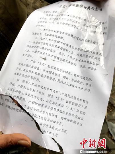 住户将2017年2月上海市水务局执法总队发放给他们的“劝离告知书”展示给记者看。 王子涛 摄