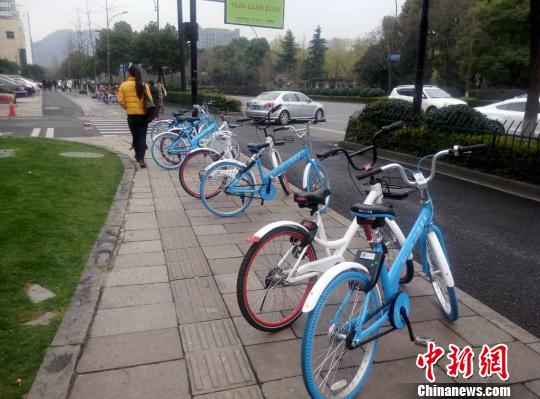 杭州一处人行道上,共享单车无序停放为行人增加了不便。 王逸飞 摄
