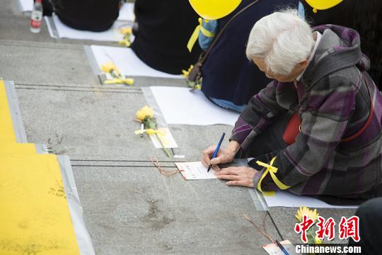 图为市民在清明公祭活动上写追思卡。 钟欣 摄