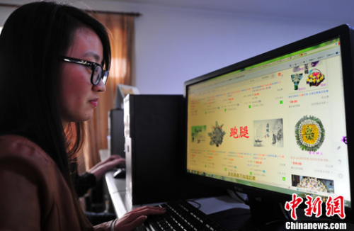 资料图：白领在网上关注“代客扫墓”的商家。中新社发 于海洋 摄