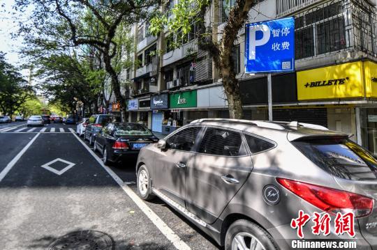 “咪表”车位附近竖立一块蓝色的牌,写着“暂停收费”。 陈骥旻 摄
