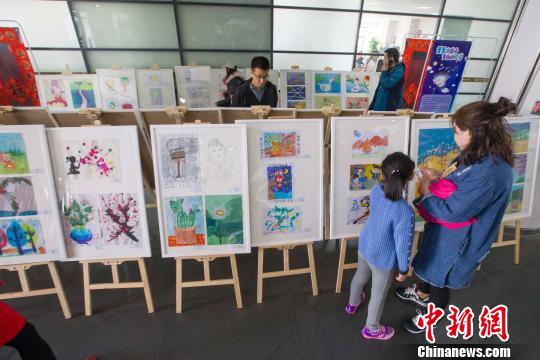山西太原,一名民众带着孩子参观画展。 张云 摄