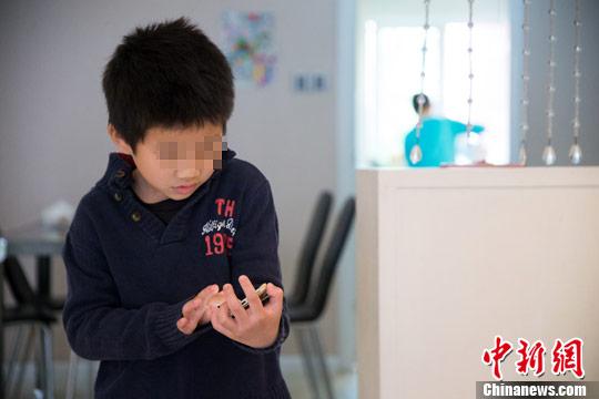妈妈在忙着准备早餐的时候,“旺仔”低着头认真地玩着手机,妈妈呼唤了他多次,他才略有反应。 李南轩 摄