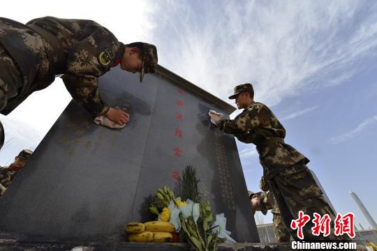 边防官兵正在擦拭牺牲的边防英烈墓碑。 吴明贤 摄