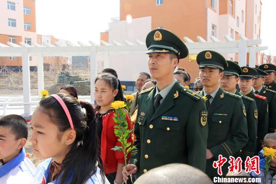 图为边防派出所官兵肃然起敬瞻仰烈士墓碑。 张辉 摄