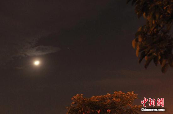 2014年5月4日晚,海南省海口市西南上空出现“木星合月”。<a target=\'_blank\' href=\'http://www.chinanews.com/\'>中新社</a>发 潘华清 摄 图片来源:CNSPHOTO