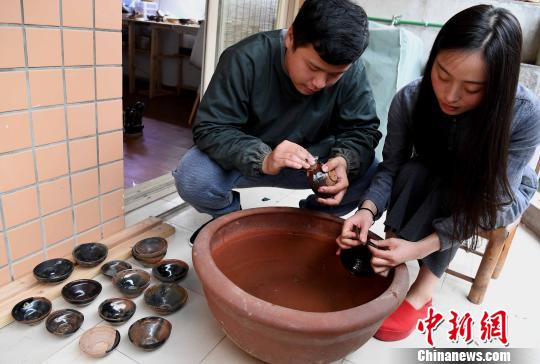 29岁的福州脱胎漆艺器物修缮师吴启彬与“90后”女友连彬彬共同将修缮过的建盏等器物进行“水磨”。 刘可耕 摄