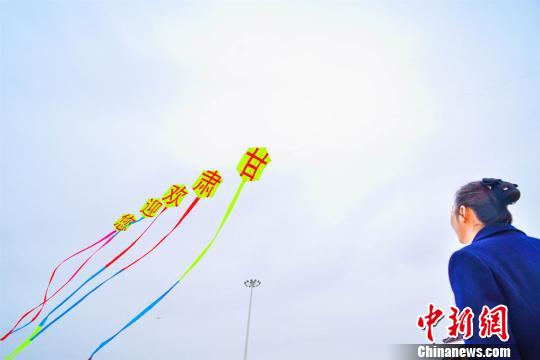 图为一位观众正在观看大型“甘肃欢迎你”的标语风筝。 王斌银 摄