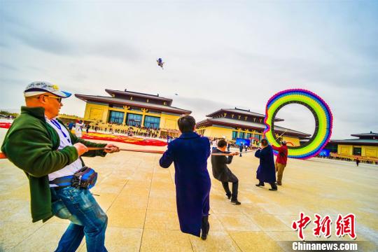 图为五位选手正在放飞直径20米的圆形风筝。 王斌银 摄