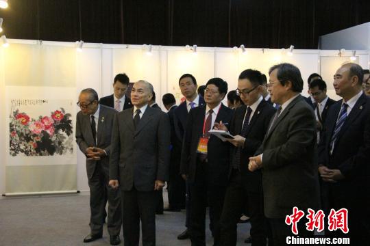 图为诺罗敦·西哈莫尼观看中国书画作品。 林波 摄