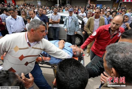 埃及官方电视台援引埃及安全部门消息称，爆炸由安置在教堂座椅下的炸弹引起。爆炸发生时，约有1000人在参加教堂内举行的弥撒。图为伤者被紧急转移。