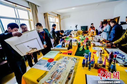 图为评审组工作人员正在对商户上报的工艺品进行评比打分。 王斌银 摄