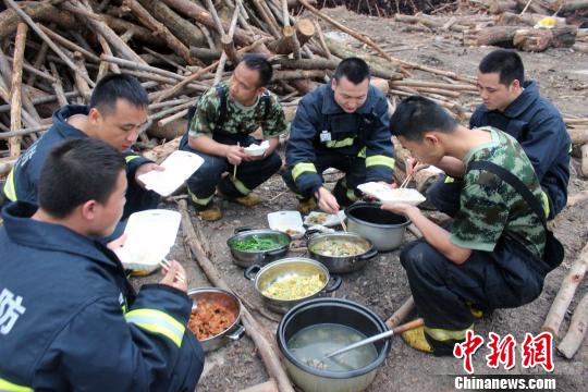 消防官兵在救援现场就餐。 何光倍 摄