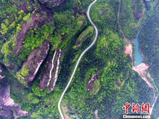 4月12日,江西省龙虎山排衙峰苍翠怡人,公路蜿蜒如长龙。 王剑 摄