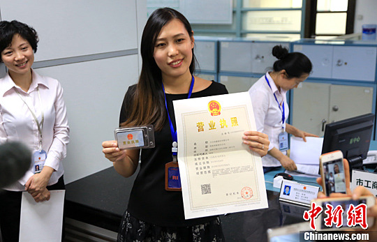 资料图:成都某传媒公司中人员展示其领取的电子营业执照。中新社发 钟欣 摄