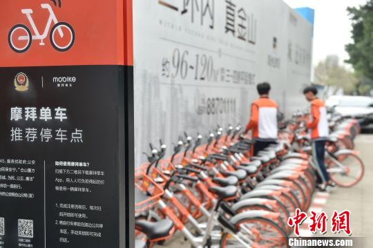 在上渡派出所门口的共享单车推荐停车点内,整齐摆放着一排的摩拜单车,已有不少市民前来取车。 张宁 摄