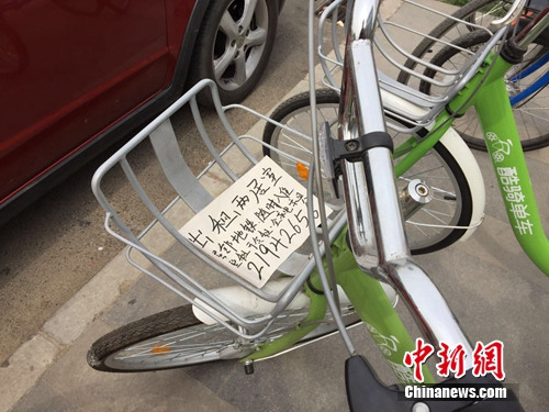 某品牌共享单车车筐内被贴上了手写的“出租房屋”小广告。中新网 吴涛 摄