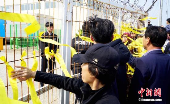 当地时间3月31日，沉船事故发生1081天后，“世越”号重新靠岸。当日，许多“世越”号遇难者家属和普通民众来到港口，等待船体靠岸。中新社记者 吴旭 摄