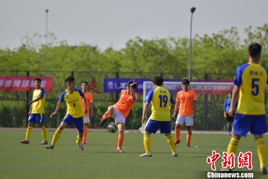 中国大学生校园足球联赛高职组北区揭幕战双方队员激烈拼抢。 佟郁 摄