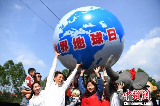 图为志愿者和市民举着“地球”共同呼吁民众保护环境、爱护地球。 陈超 摄