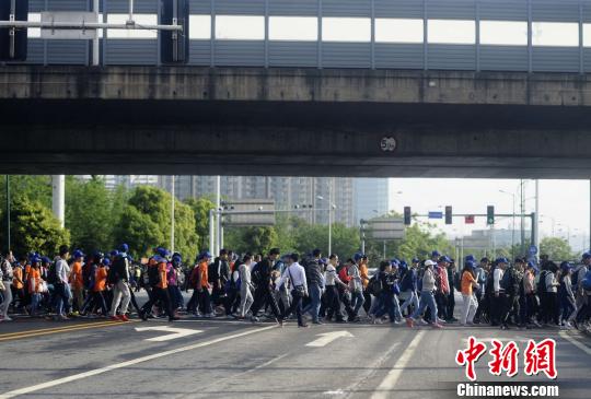 毅行者正在过马路。 杨华峰 摄