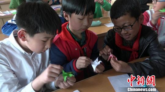 小学生在折纸手工课上折出可以扇动翅膀的小燕子。 屈丽霞 摄