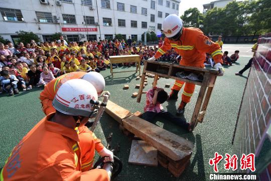 消防员在向分宜县第二小学学生进行救援模拟演练。 周亮 摄