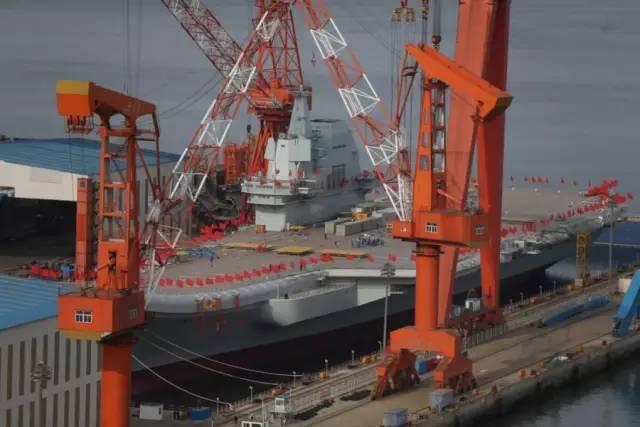 25日,国产航母插满红旗准备下水