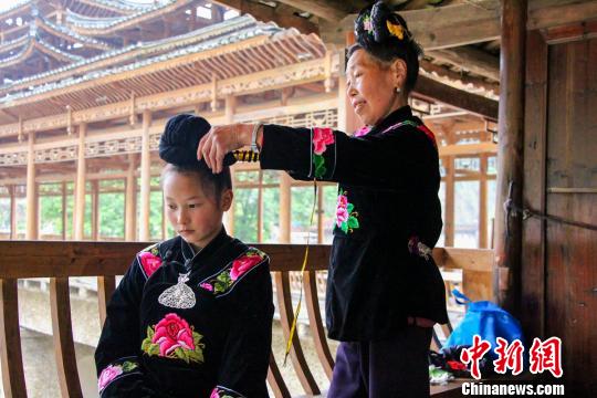 图为文海燕的奶奶教授她挽苗鬏鬏(苗族发型)。 文寿 摄