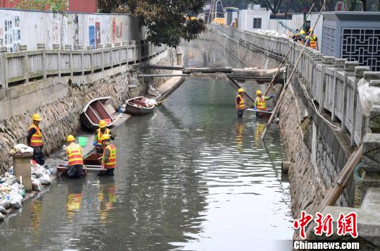 5月2日,在福州鼓台中心区水系综合治理项目包的屏东河项目现场,数十名工人在河道中将淤泥装进编织袋后运上岸。 刘可耕 摄