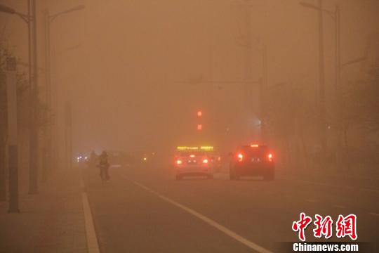 内蒙古地区迎来今年最强沙尘暴，图为车辆在沙尘中缓慢行驶。　李爱平 摄