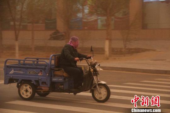 内蒙古地区迎来今年最强沙尘暴，图为沙尘中的行人。　李爱平 摄