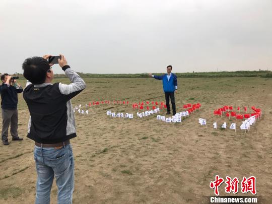 外场观众在地上摆放的c919图案的旗帜前合影。 王子涛 摄