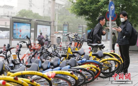 5月5日,北京遭遇大风扬沙天气,气象台发布大风黄色预警,阵风达8、9级,局地伴有扬沙。图为街头被大风吹倒的一排共享单车。中新社记者 廖文静 摄