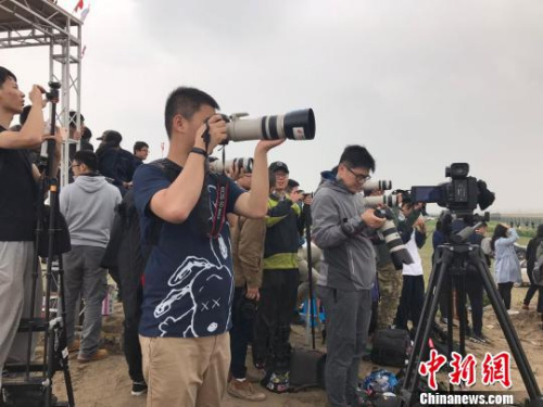 c919首飞跑道外的空地上聚集了不少观众。 王子涛 摄